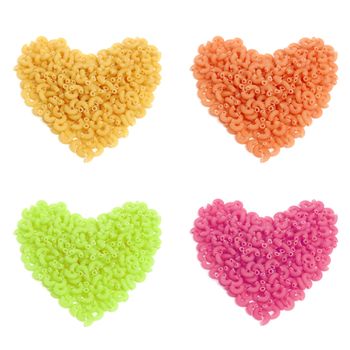 Colorful macaroni in heart shape isolated on white background 