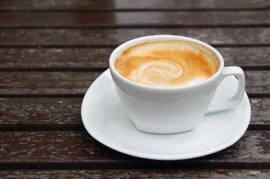 Cup of hot coffee on wooden table