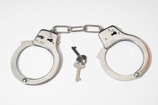 One Pair of Handcuffs on a Colored Background