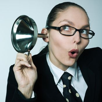 studio shot portrait of one caucasian curious business woman  hearing aid funnel curious spying gossip