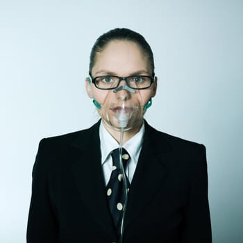 studio shot portrait of one caucasian young breathless business woman  with oxygen mask