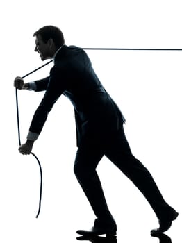one caucasian business man pulling a rope in silhouette studio isolated on white background