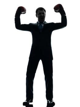 one caucasian businessman with boxing gloves   in silhouette studio isolated on white background