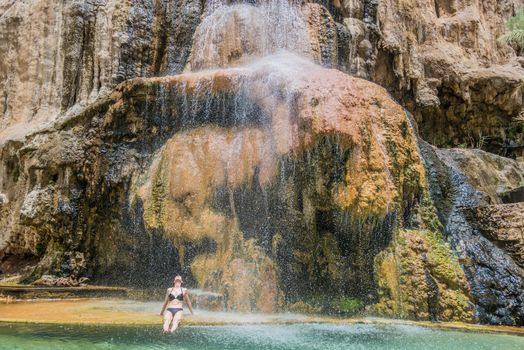 one woman bathing at ma'in hot springs waterfall  in jordan middle east