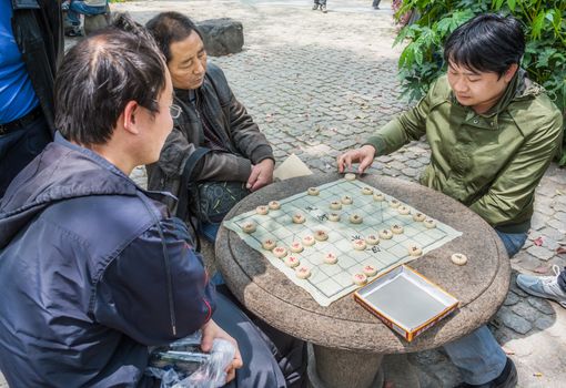 Shanghai, China - April 7, 2013: people playing chinese chess in people's park  at the city of Shanghai in China on april 7th, 2013