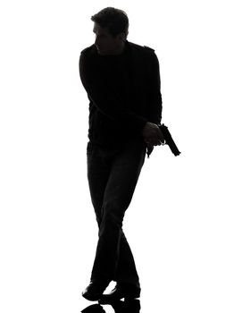 one man killer policeman holding gun walking silhouette studio white background