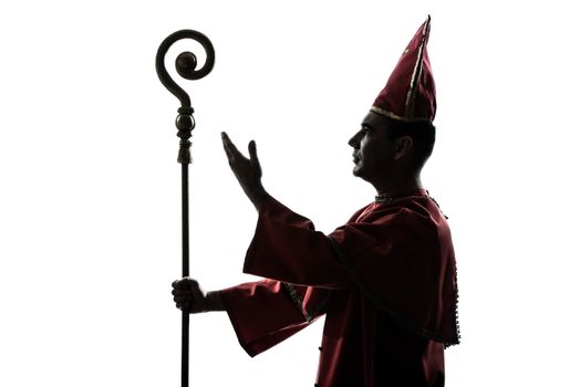 one man cardinal bishop silhouette saluting blessing in studio isolated on white background