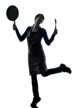 one caucasian woman happy cooking holding frying pan  in silhouette studio isolated on white background
