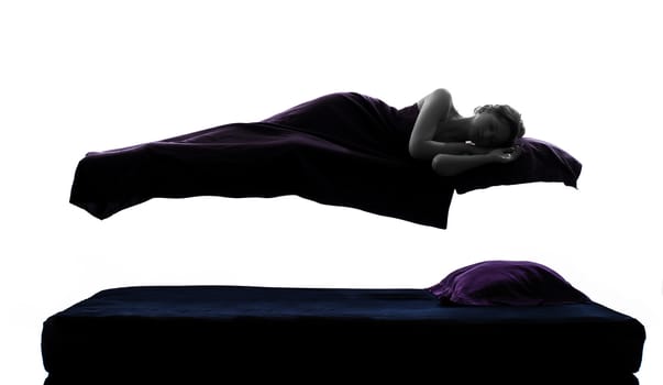 one woman sleeping in levitation on bed silhouette studio on white background