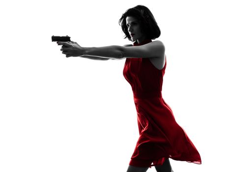 one sexy caucasian woman holding gun in silhouette studio isolated on white background