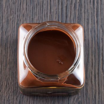 Chocolate cream in closeup from above, over wooden background