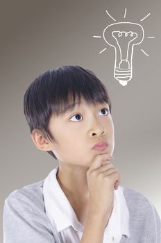 A young child is thinking a drawing of a light bulb