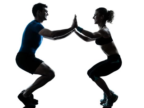 one caucasian couple man woman personal trainer coach exercising squatts silhouette studio isolated on white background