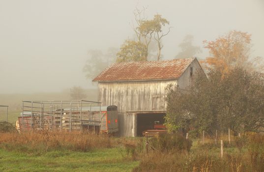 old barn in the countryside on a foggy, overcast day