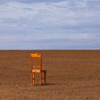 Lonely chair on a cultivated field