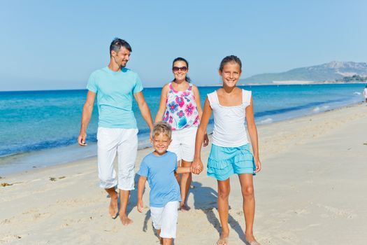 Family of four having fun on tropical beach