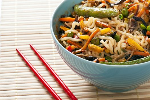 Asian Noodles and Fried Vegetables in Bowl with Chopsticks