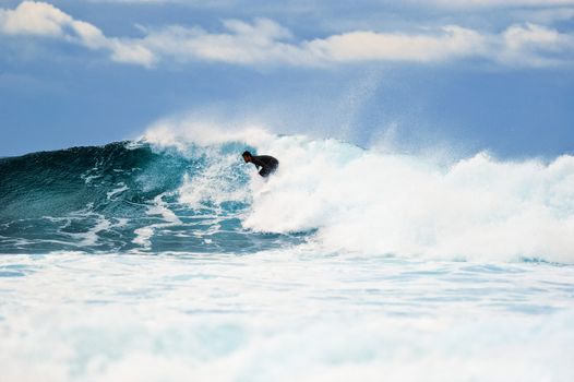 Surfer riding on a large wave on the Atlantic Coast. Canary island, Spain