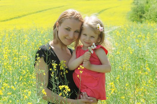 Happy mother and daughter in rapeseed field