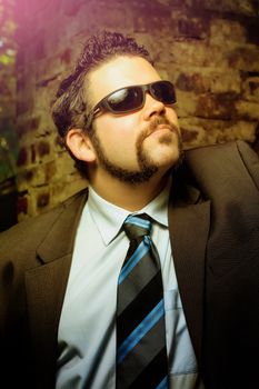 Businessman with sunglasses and beard looking up outdoor