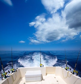 Fishing boat stern deck with trolling fishing rods and reels in blue ocean sea