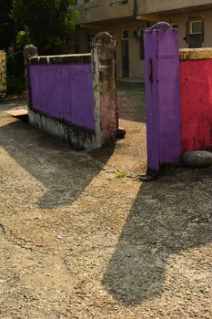 Aged colorful stone fence in sunny day.