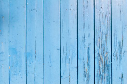 light blue painted planks of old shed with peeling paint