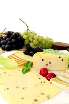 a white plate of various cheeses