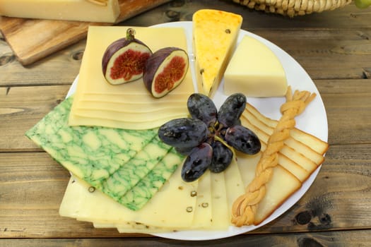 a white plate of various cheeses