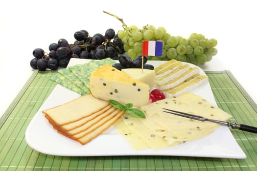 a white plate of various cheeses