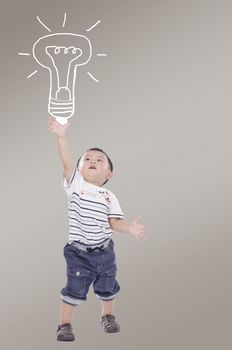 A cute boy is catching a drawing of a light bulb