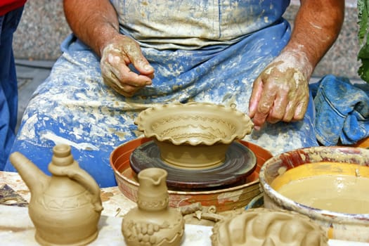 Close up of potter's hands making clay pot