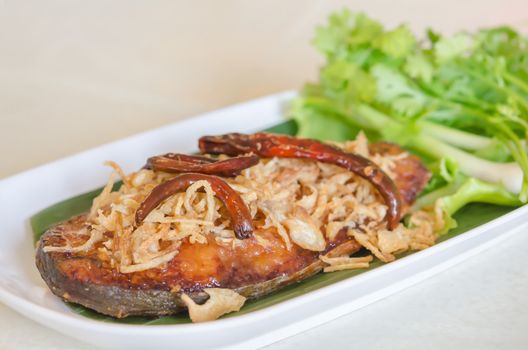 Fried pickled fish , onion  and chili served  with fresh vegetable on dish