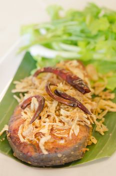 close up fried pickled fish , onion  and chili served  with fresh vegetable