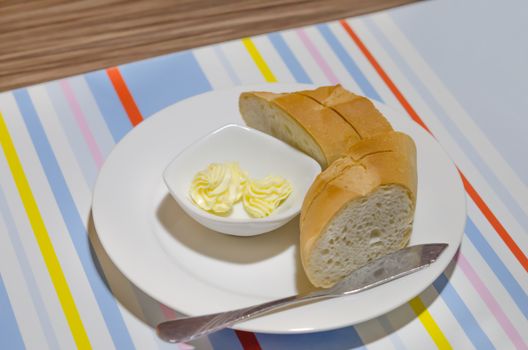 cheese in bowl  and slice of bread  on white plate