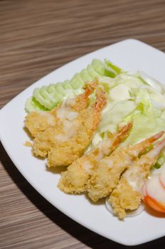 deep fried shrimp and  fresh vegetable salad with cream sauce on dish