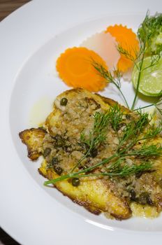 fish steak served with  vegetable on white dish