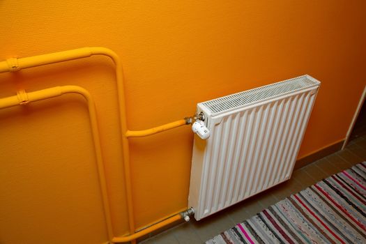 Heating radiator detail against orange wall