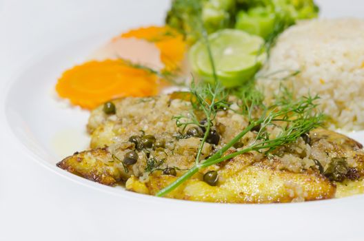 close up fish steak served with  vegetable and fried rice on white dish
