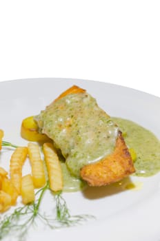 roasted salmon served with green sauce and french fries  on  plate over white background