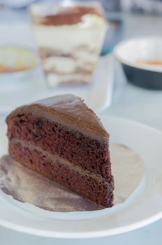 close up slice of chocolate fudge cake on white dish