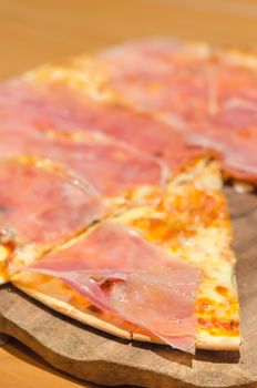 close up fast food ,  homemade crispy  pizza with ham over wooden plate