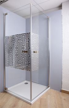 Brand new shower on bright background and wooden floor