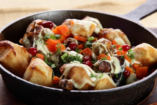 roasted potatoe with mushrooms on hot black pan