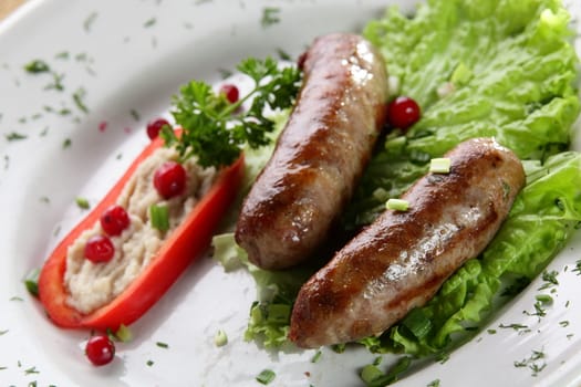 roasted sausages with pepper and berries in white pan