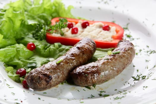 roasted sausages with pepper and berries in white pan