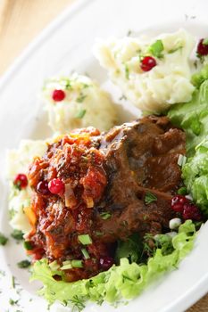 roasted meat with salad and potato in white dish