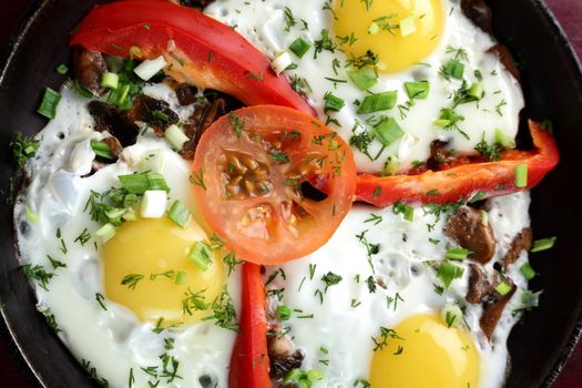 eggs with pepper and tomato on black pan