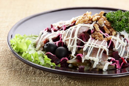 salad with fish and nuts in black dish