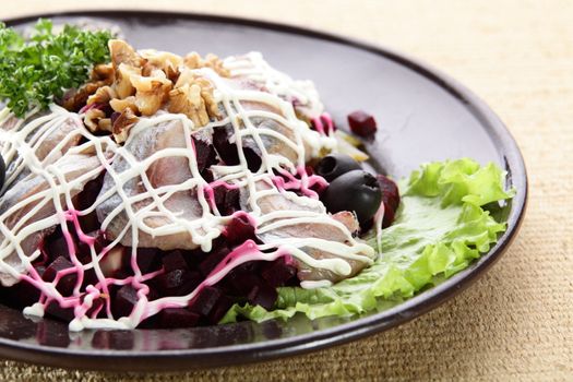 salad with fish and nuts in black dish